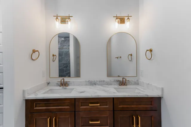 a bathroom with a granite countertop sink and a mirror