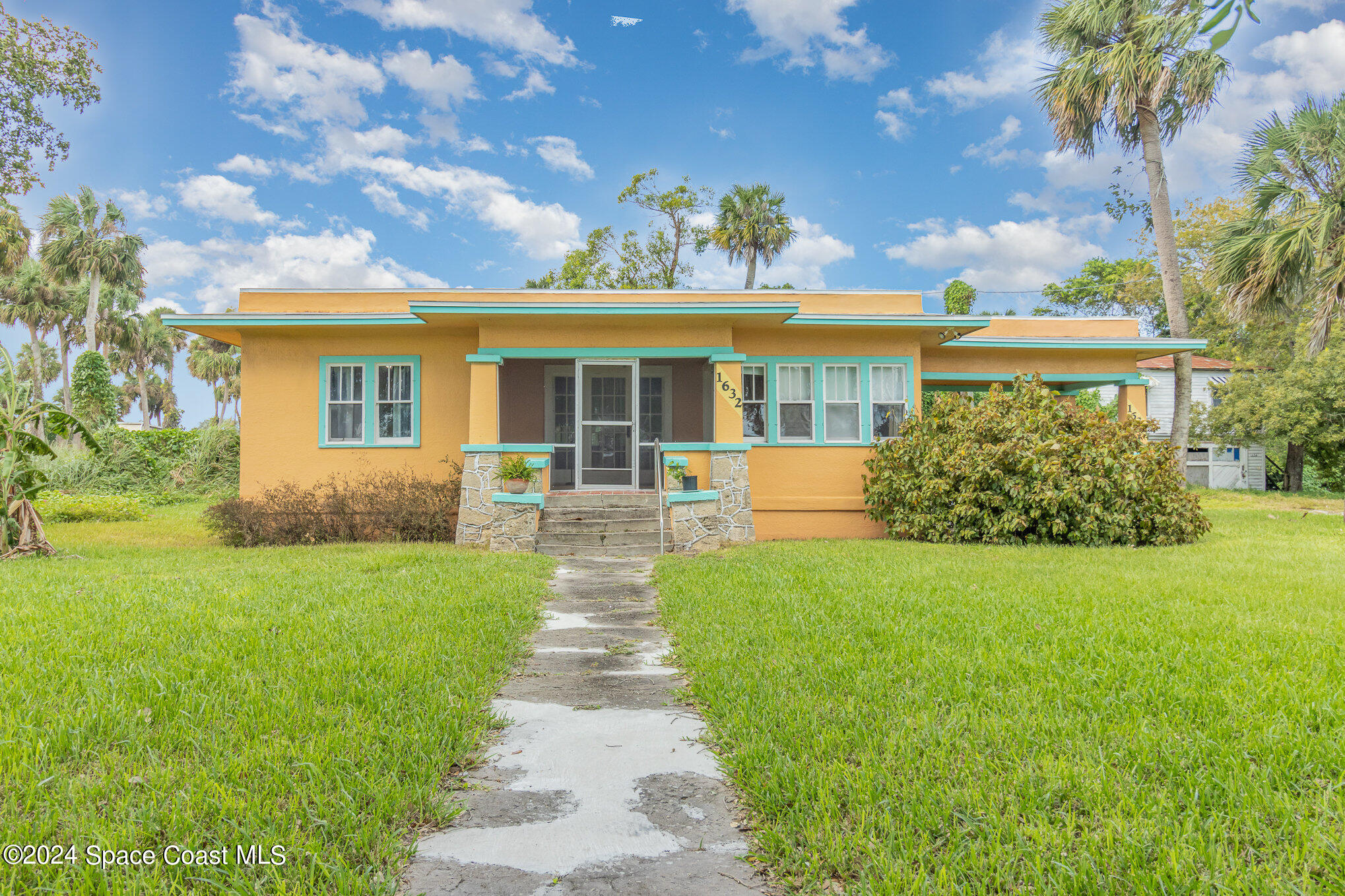 1632 Water Drive Northeast Palm Bay, FL 32905 - Photo 2 of 31 a front view of a house with garden