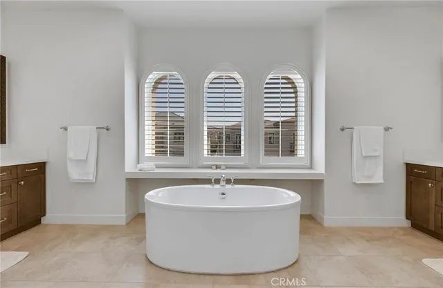 a white bath tub sitting in a bathroom next to a window