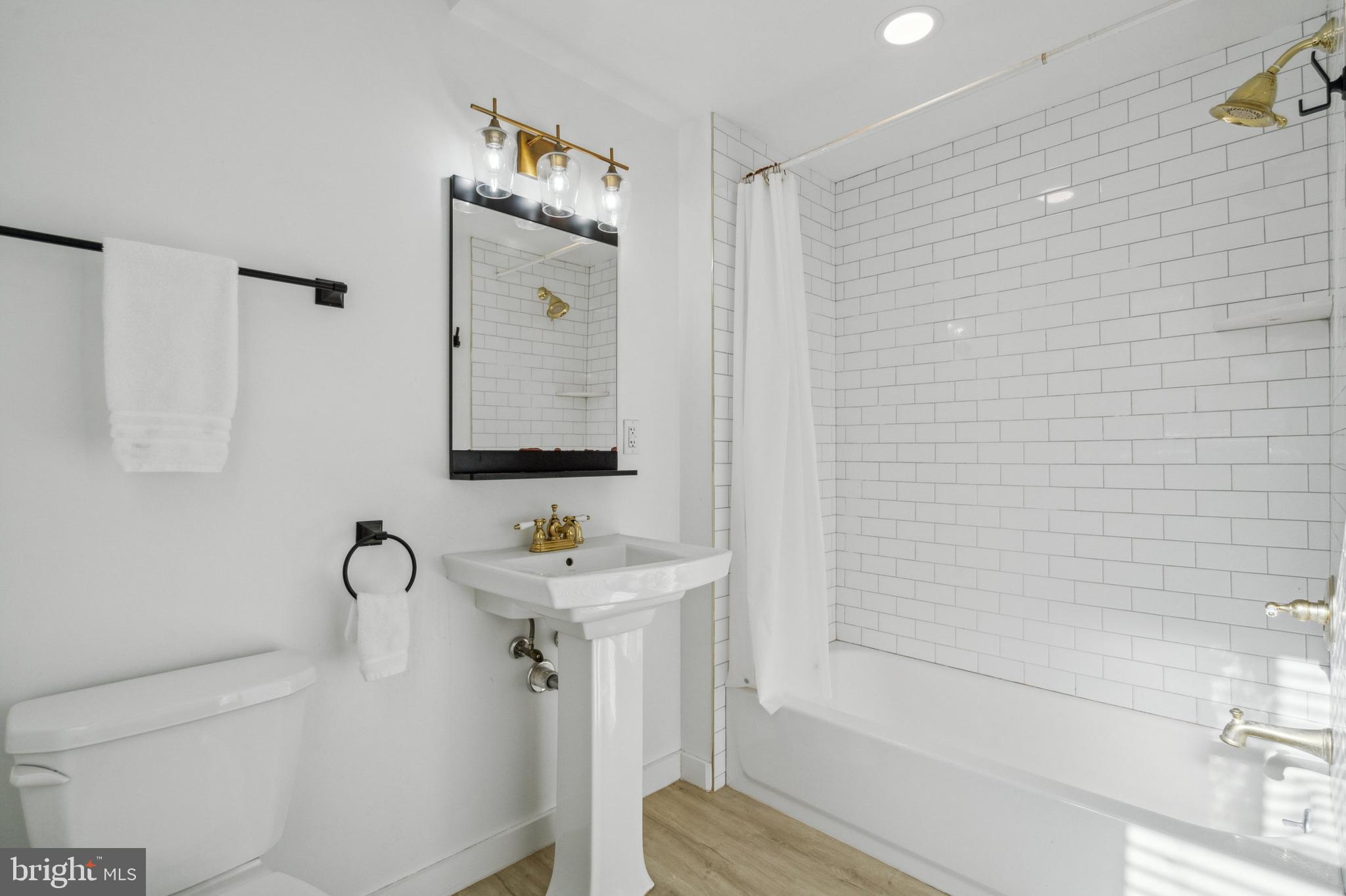 2006 Pine Street, Unit 2 Philadelphia, PA 19103 - Photo 10 of 12 a bathroom with a sink and mirror with bathtub