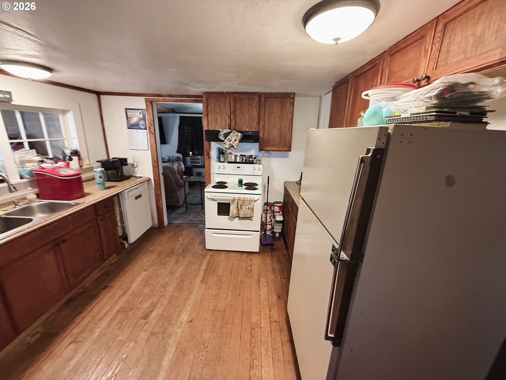 827 East 11th Street Coquille, OR 97423 - Photo 25 of 45 a kitchen with a refrigerator a stove top oven and a sink with cabinets