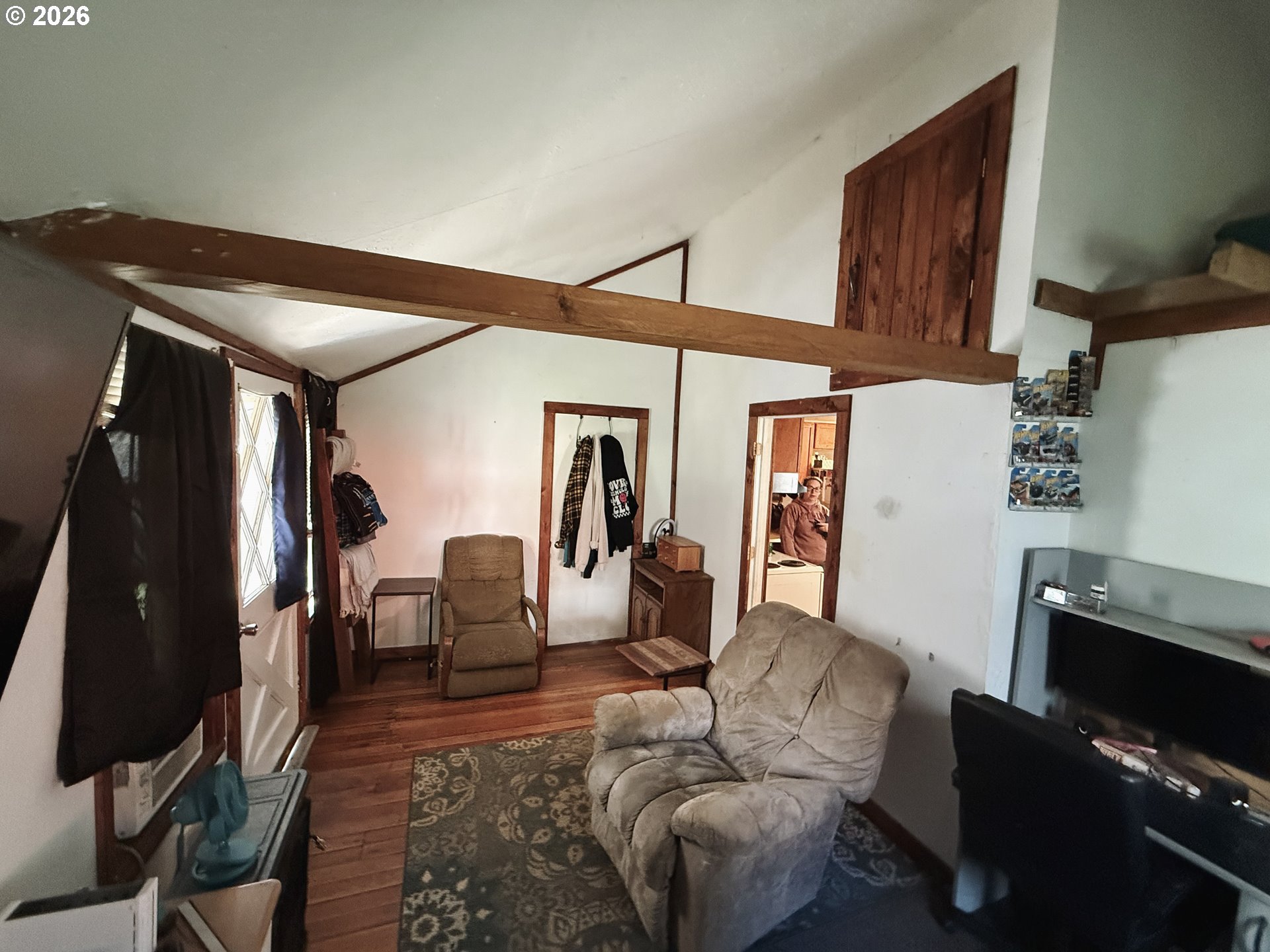827 East 11th Street Coquille, OR 97423 - Photo 33 of 45 a living room with furniture a flat screen tv and a refrigerator