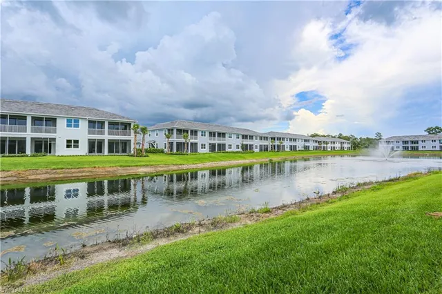a view of a house with yard and lake view