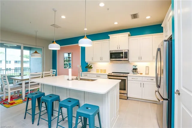 a kitchen with a sink a stove a refrigerator and black cabinets