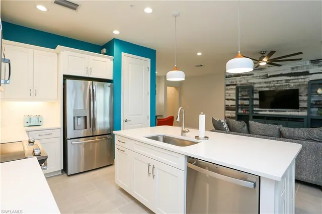 a kitchen with a sink stainless steel appliances and white cabinets