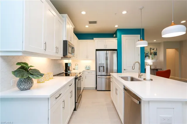 a kitchen with a sink a refrigerator and a stove top oven