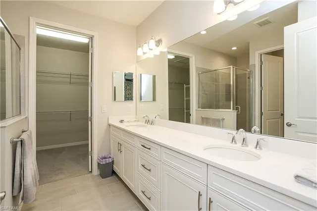 a bathroom with a double vanity sink mirror and shower