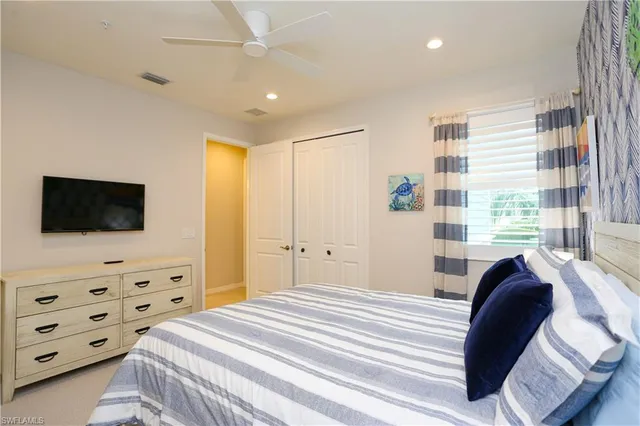 a bedroom with a bed a flat screen tv and a dresser