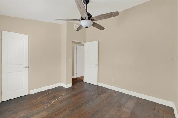 a view of a room with wooden floor and a ceiling fan