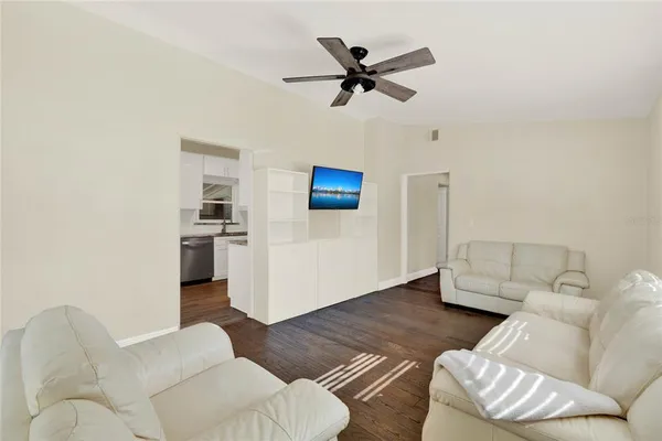 a living room with furniture and a view of kitchen