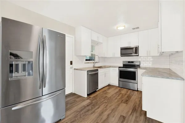 a kitchen with a refrigerator a stove top oven a sink and dishwasher