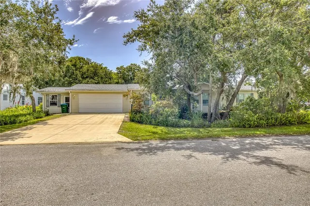 a view of a house with garage and a yard