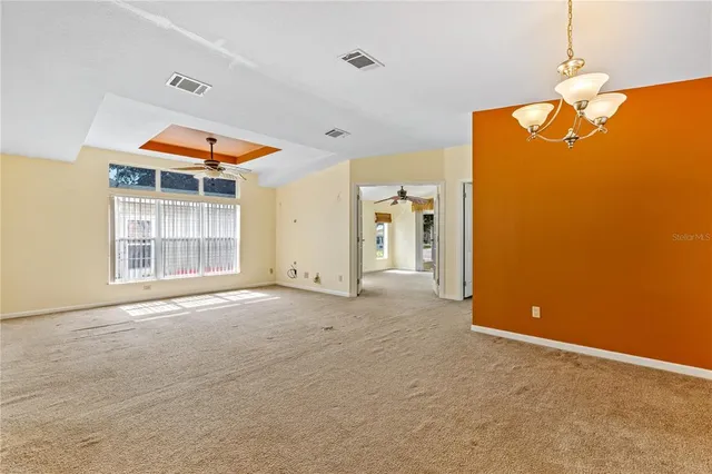 a view of a room with a ceiling fan and a window