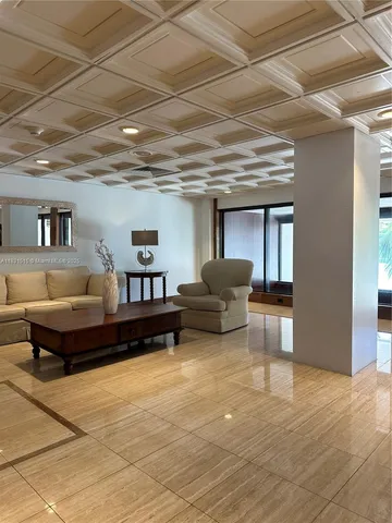 a lobby with furniture and a glass door with couch