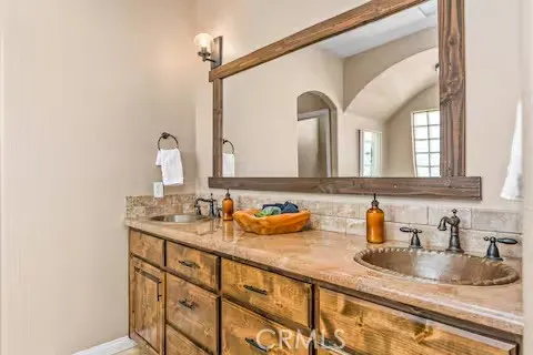 a bedroom with a bed ceiling fan and a large mirror