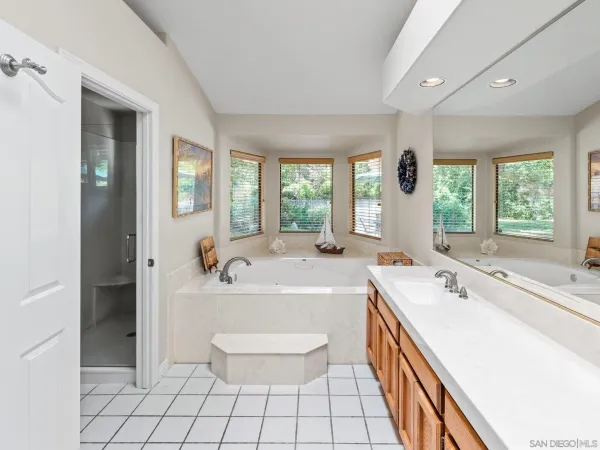 a spacious bathroom with a tub sink and mirror