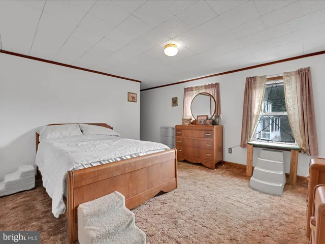 a bedroom with a bed and a dresser with the shoe rack