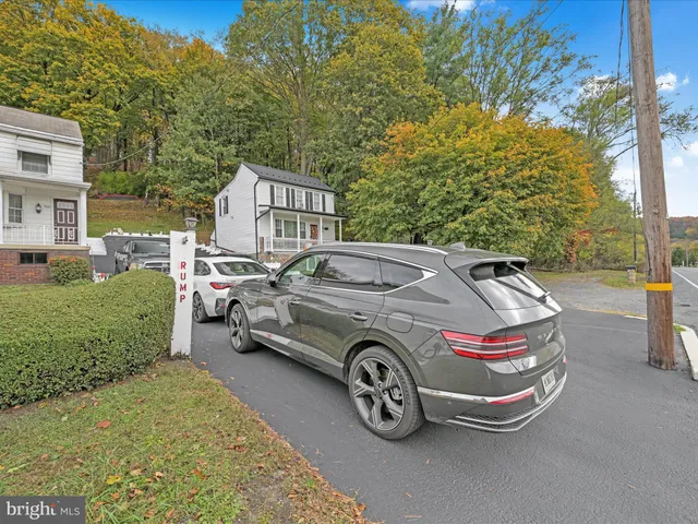 a front view of a house with a garden and parking space