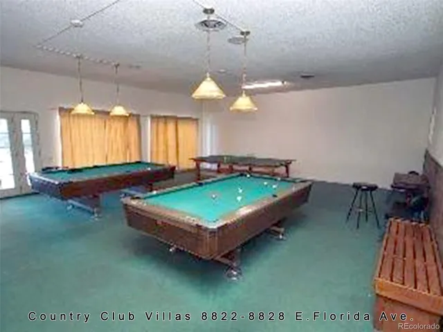 a room with pool table and windows