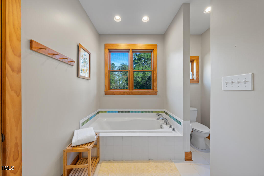 10714 Wilkins Road Rougemont, NC 27572 - Photo 13 of 40 a bathroom with a tub and a window