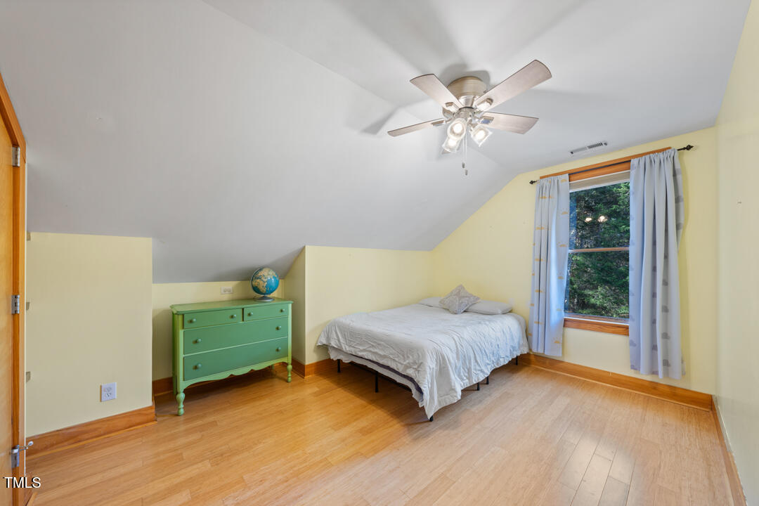 10714 Wilkins Road Rougemont, NC 27572 - Photo 19 of 40 a bedroom with two beds and a chandelier