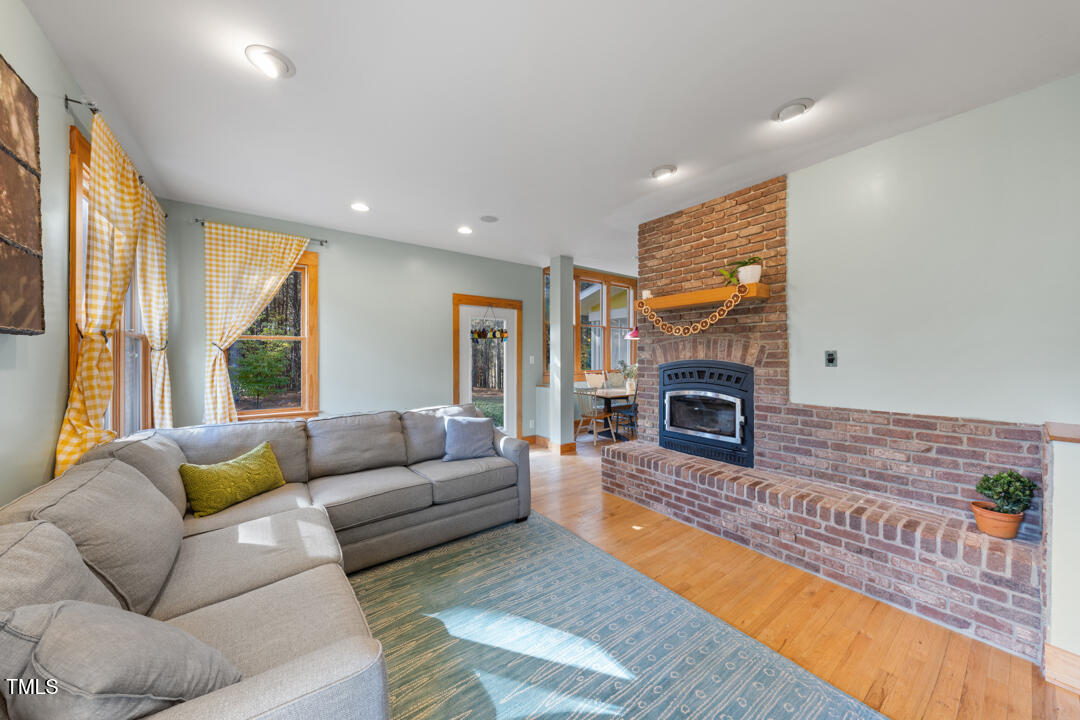 10714 Wilkins Road Rougemont, NC 27572 - Photo 9 of 40 a living room with furniture a large window and a fireplace