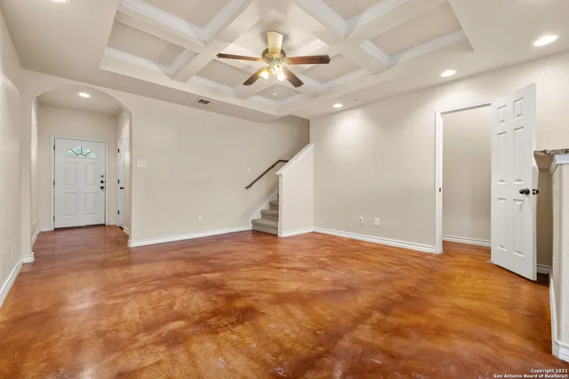 an empty room with fan and entryway