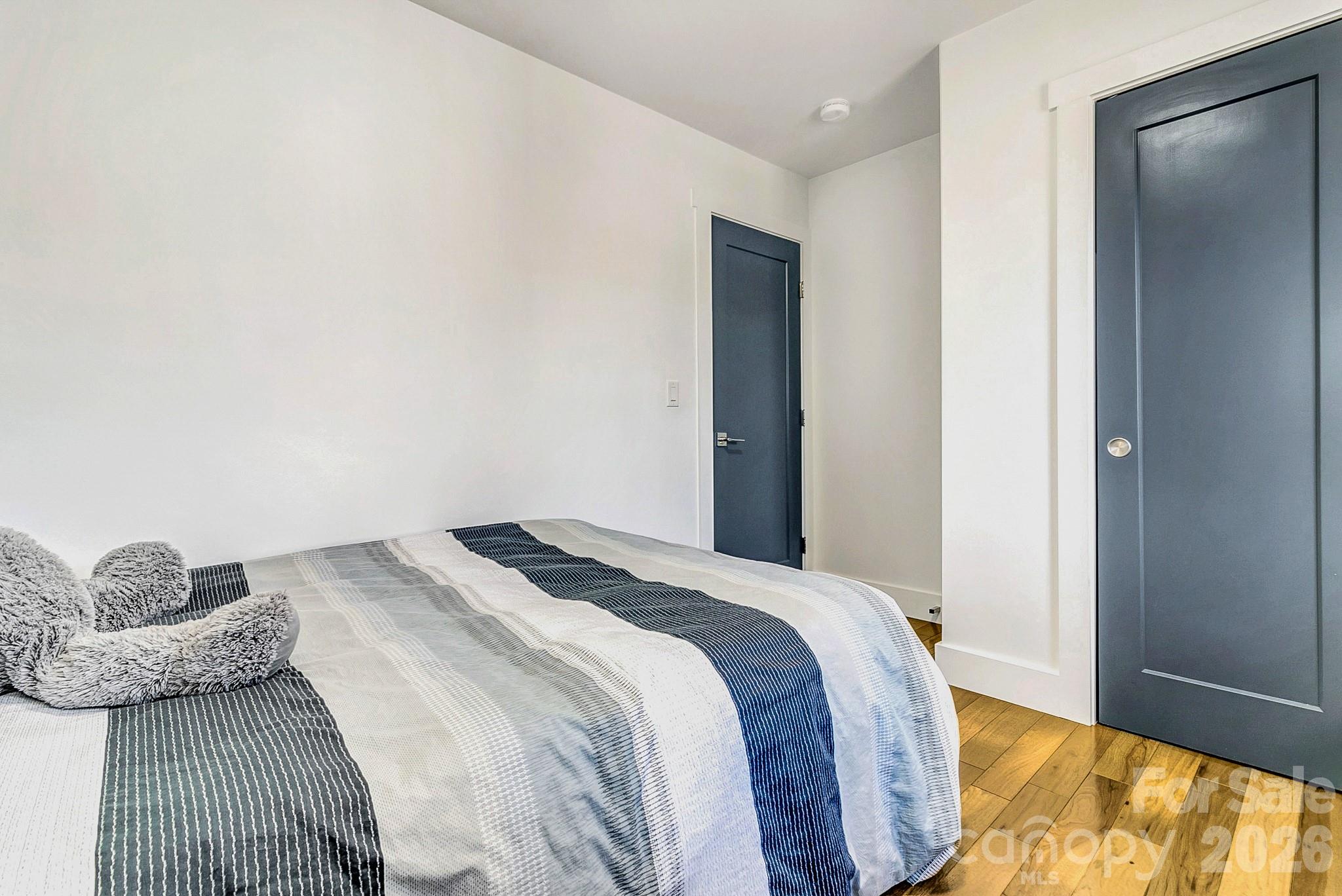 215 East Oakview Road Asheville, NC 28806 - Photo 30 of 42 a bedroom with a bed and a painting on the wall