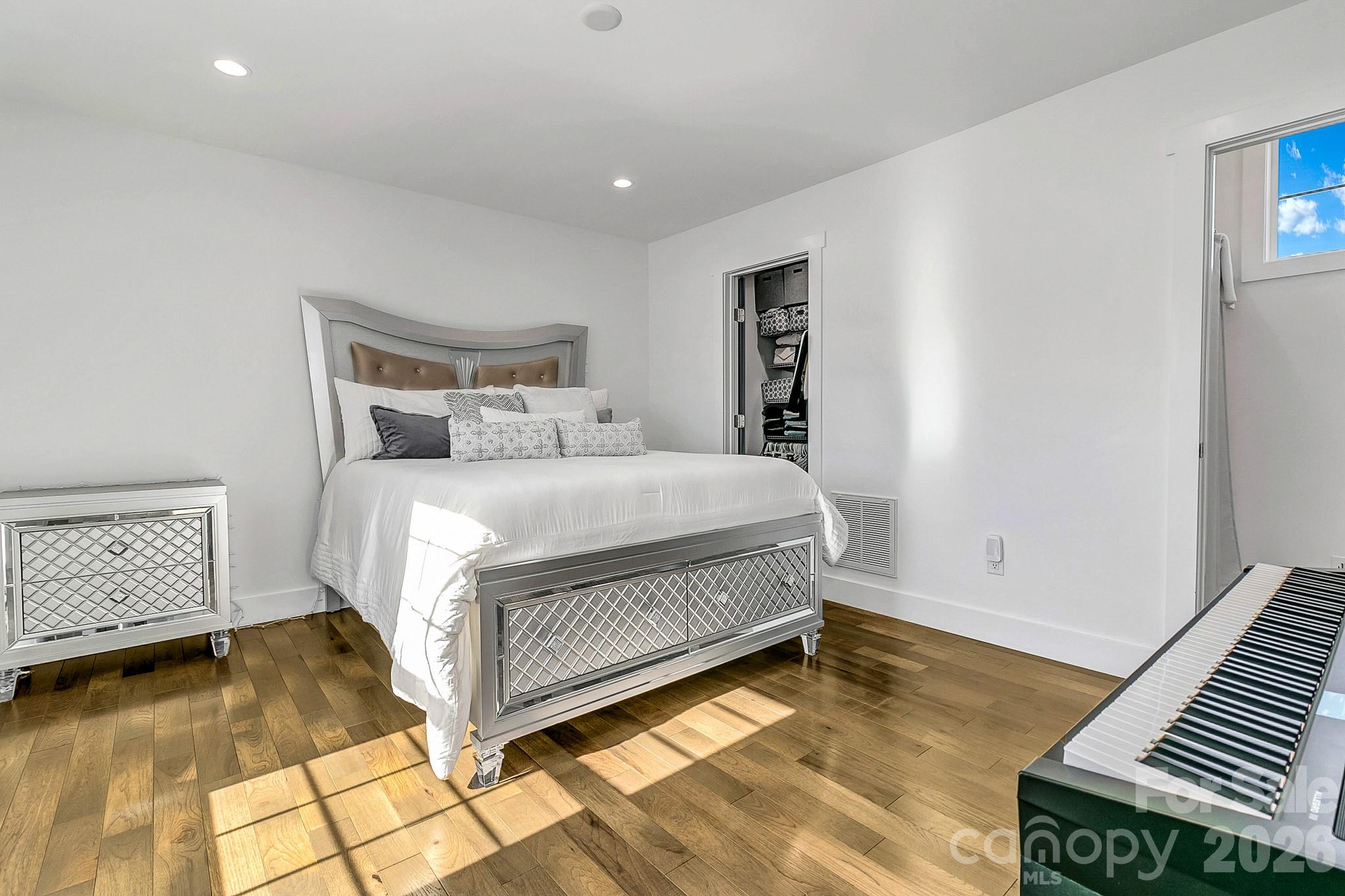 215 East Oakview Road Asheville, NC 28806 - Photo 32 of 42 a bedroom with a bed and a table with wooden floor