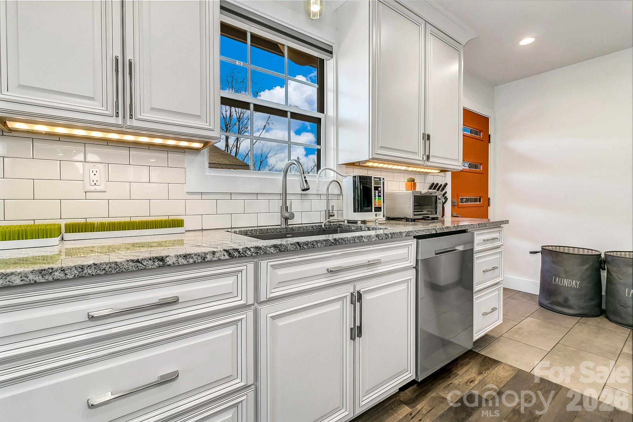 215 East Oakview Road Asheville, NC 28806 - Photo 9 of 42 a kitchen with stainless steel appliances granite countertop a sink and cabinets