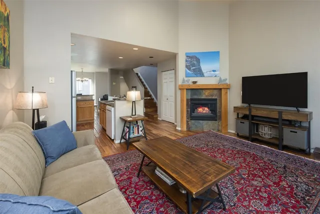 a living room with furniture a flat screen tv and a fireplace