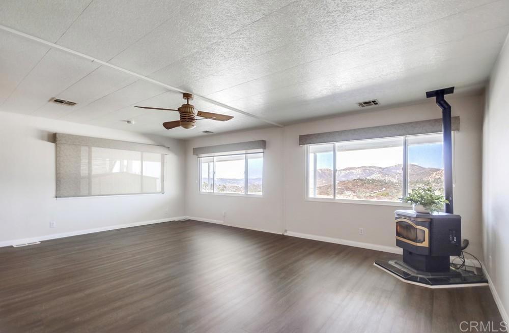 9500 Harritt Road, Unit 70 Lakeside, CA 92040 - Photo 3 of 21 a room with wooden floor a ceiling fan and windows