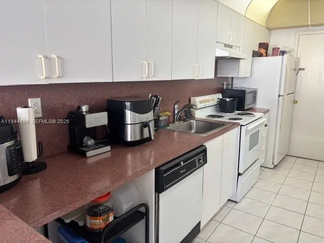 a kitchen with a sink appliances and cabinets