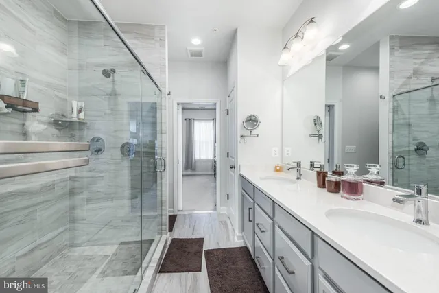 a spacious bathroom with a double vanity sink mirror and shower