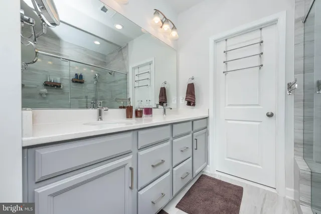 a bathroom with a double vanity sink a mirror and a shower