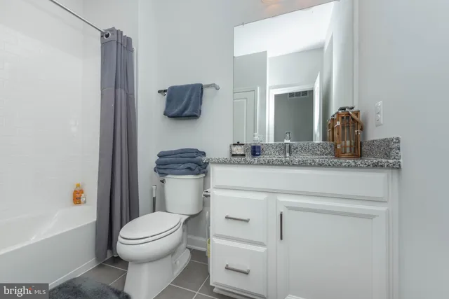 a bathroom with a granite countertop toilet sink and mirror