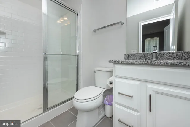 a bathroom with a granite countertop toilet sink and shower