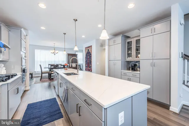 a large kitchen with stainless steel appliances and white cabinets