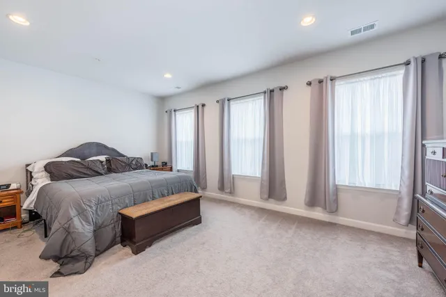 a spacious bedroom with a bed and a window