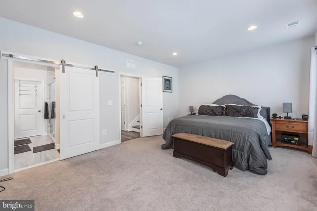 a spacious bedroom with a bed and a view of bathroom