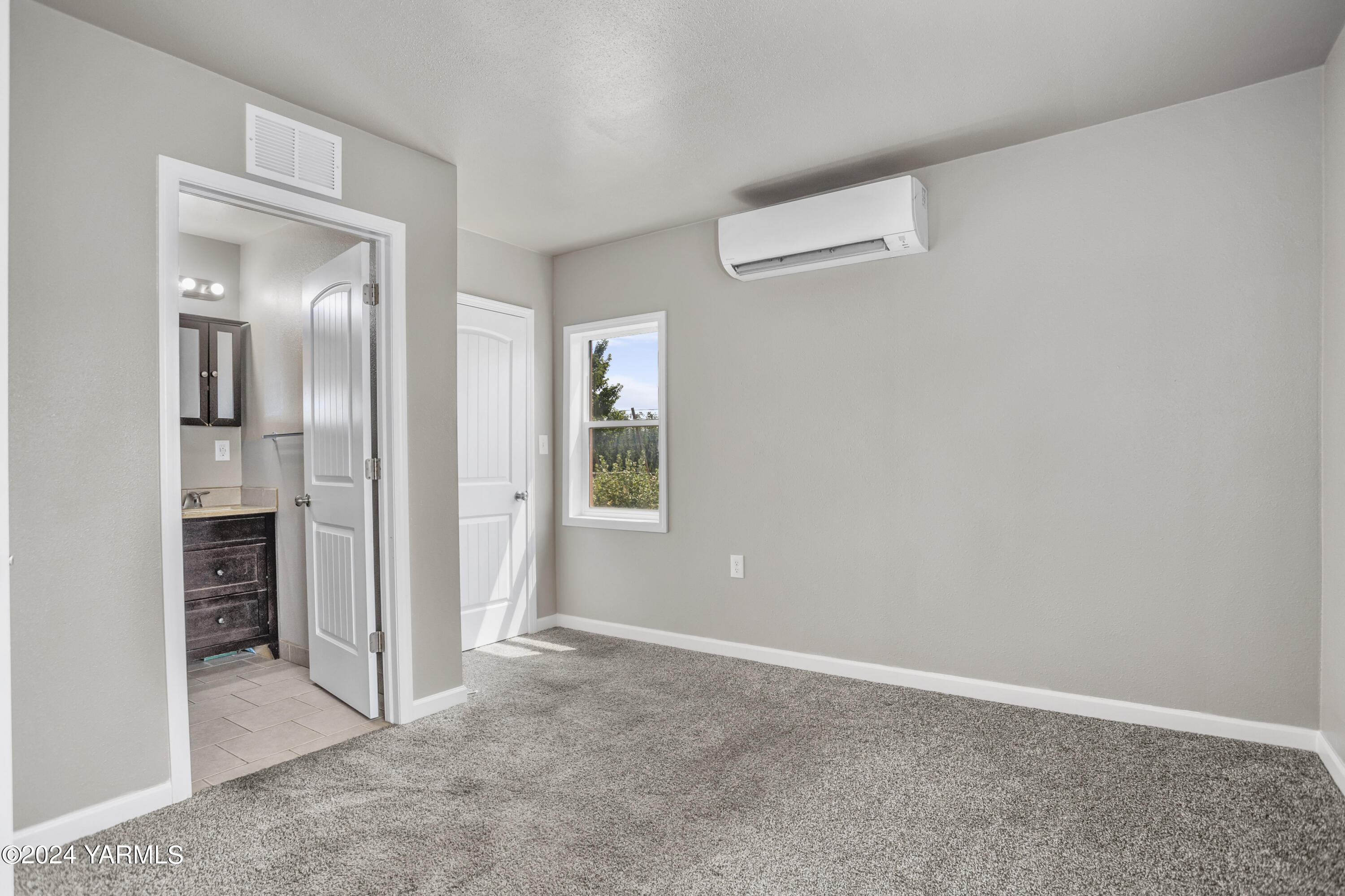 178409 West Apricot Road Grandview, WA 98930 - Photo 21 of 43 an empty room with windows and entrance to other room