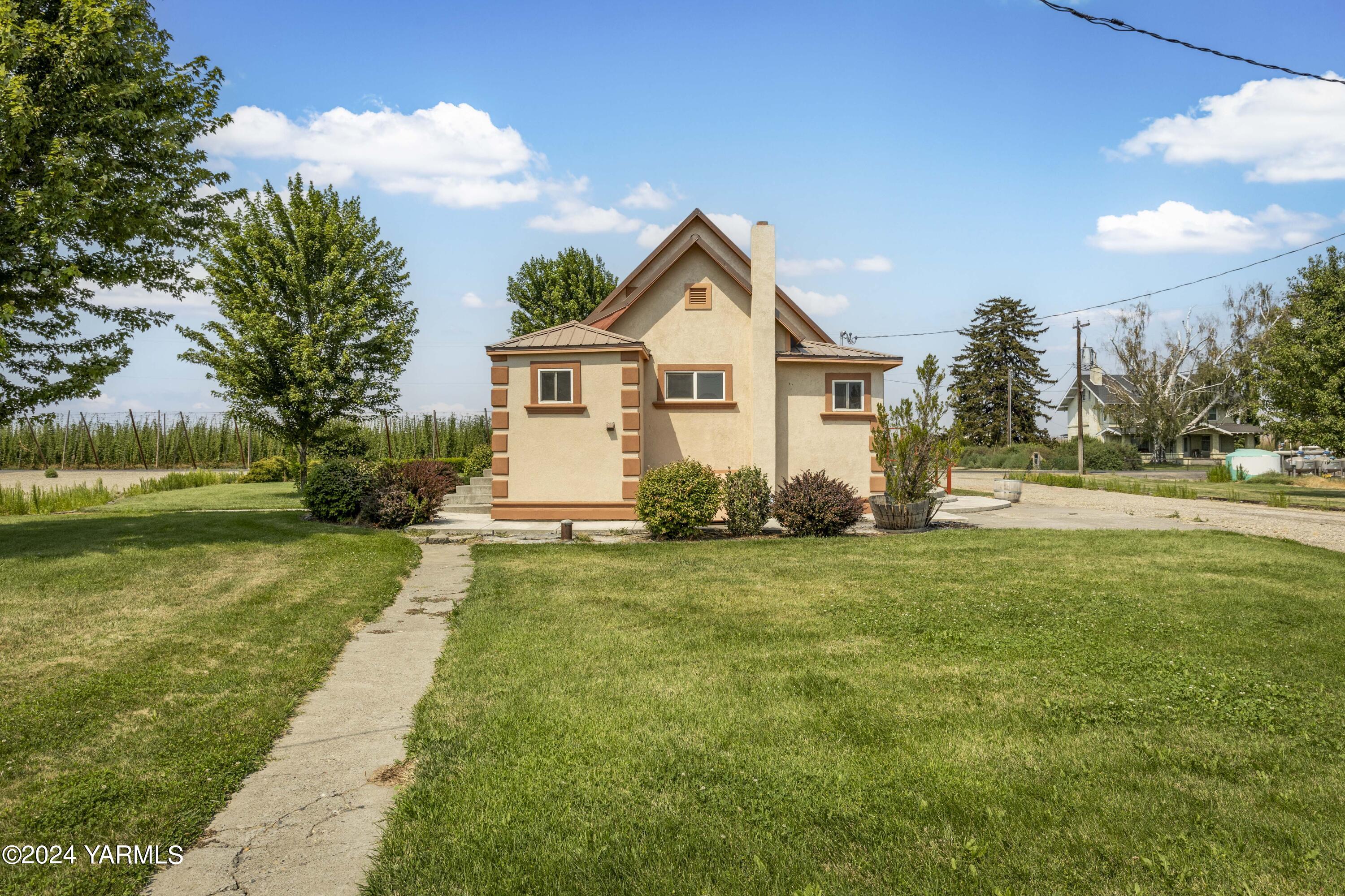 178409 West Apricot Road Grandview, WA 98930 - Photo 6 of 43 a front view of a house with a yard