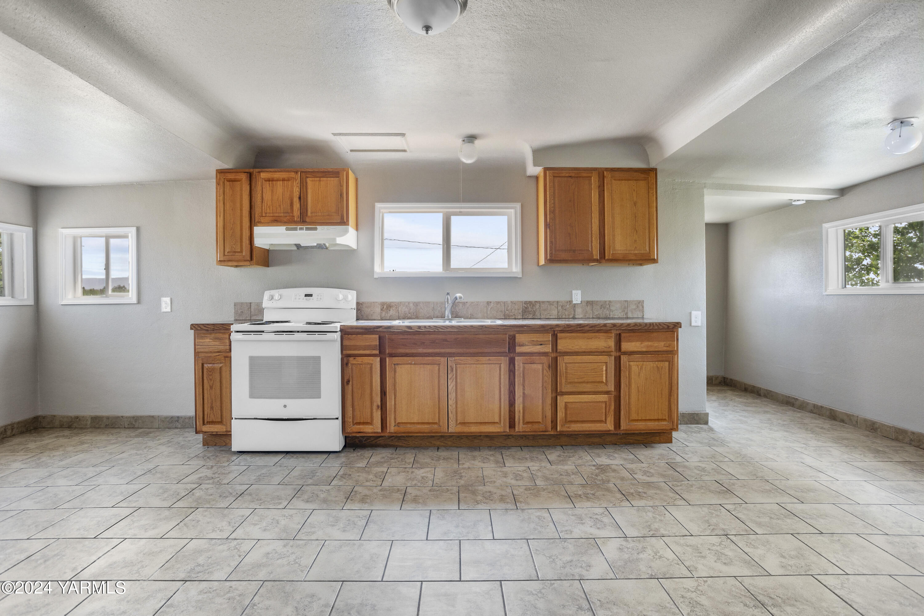 178409 West Apricot Road Grandview, WA 98930 - Photo 10 of 43 a kitchen with a stove a sink and a refrigerator