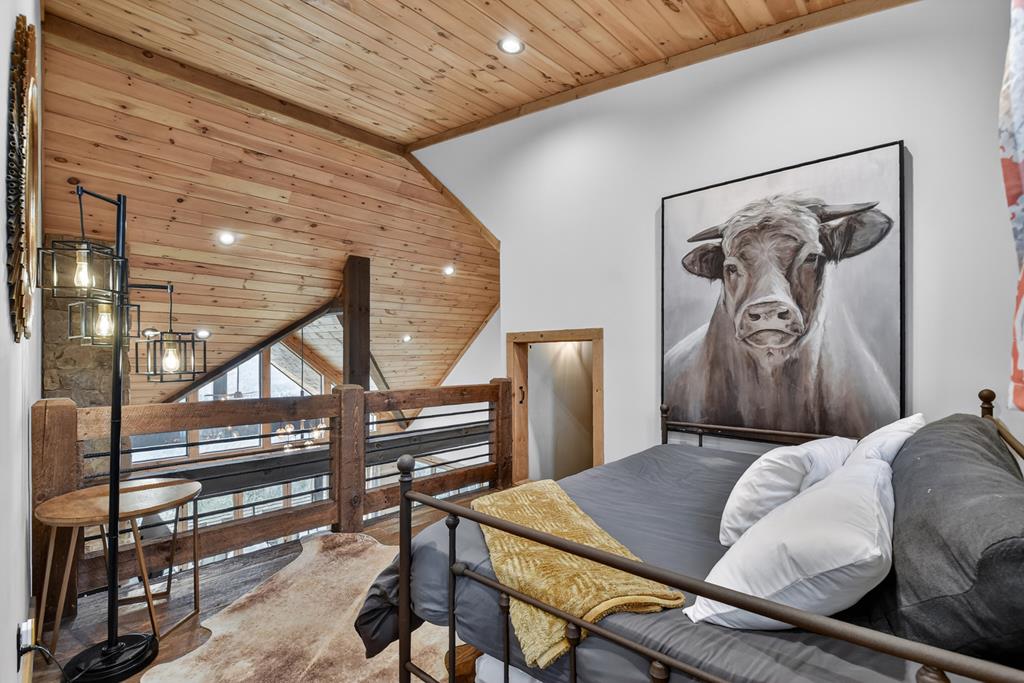 472 Overlook Drive Blue Ridge, GA 30513 - Photo 20 of 58 a bedroom with a bed a desk and chair with the wooden floor