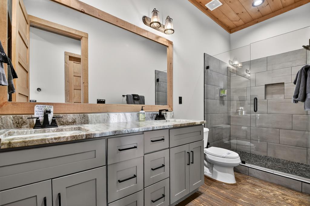 472 Overlook Drive Blue Ridge, GA 30513 - Photo 30 of 58 a bathroom with a granite countertop toilet sink shower and mirror