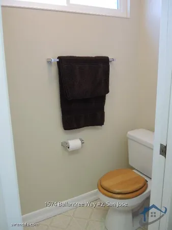 a bathroom with a toilet and a picture