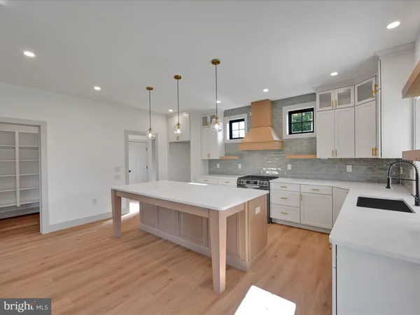 a large kitchen with stainless steel appliances granite countertop a sink a stove a kitchen island with wooden cabinets