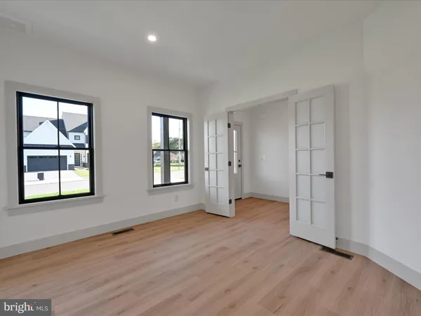 an empty room with wooden floor and windows