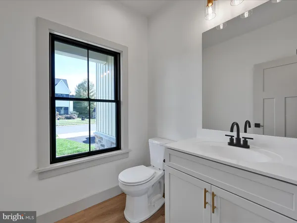 a bathroom with a toilet sink vanity and mirror