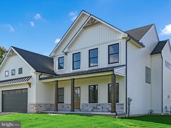 a view of a white house with large windows and a yard in front of it